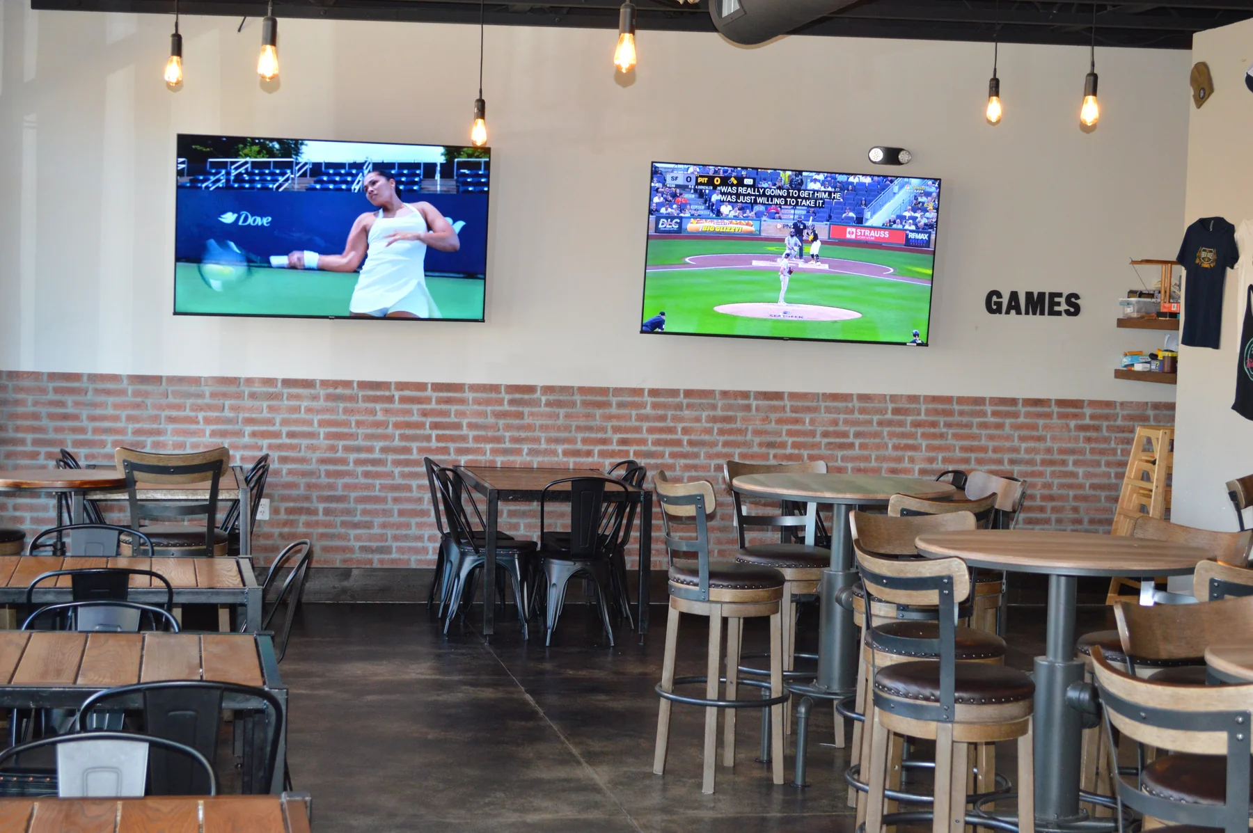 The Beer Aisle seating area with big-screen televisions above a brick accent wall.
